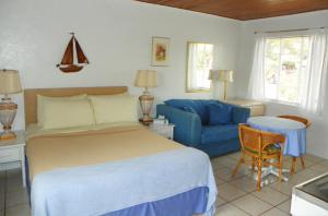 Standard Queen room with a queen bed, blue sofa, and tiled floors